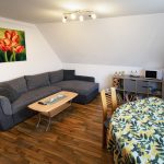 Wohnzimmer mit Tisch und Küchenzeile